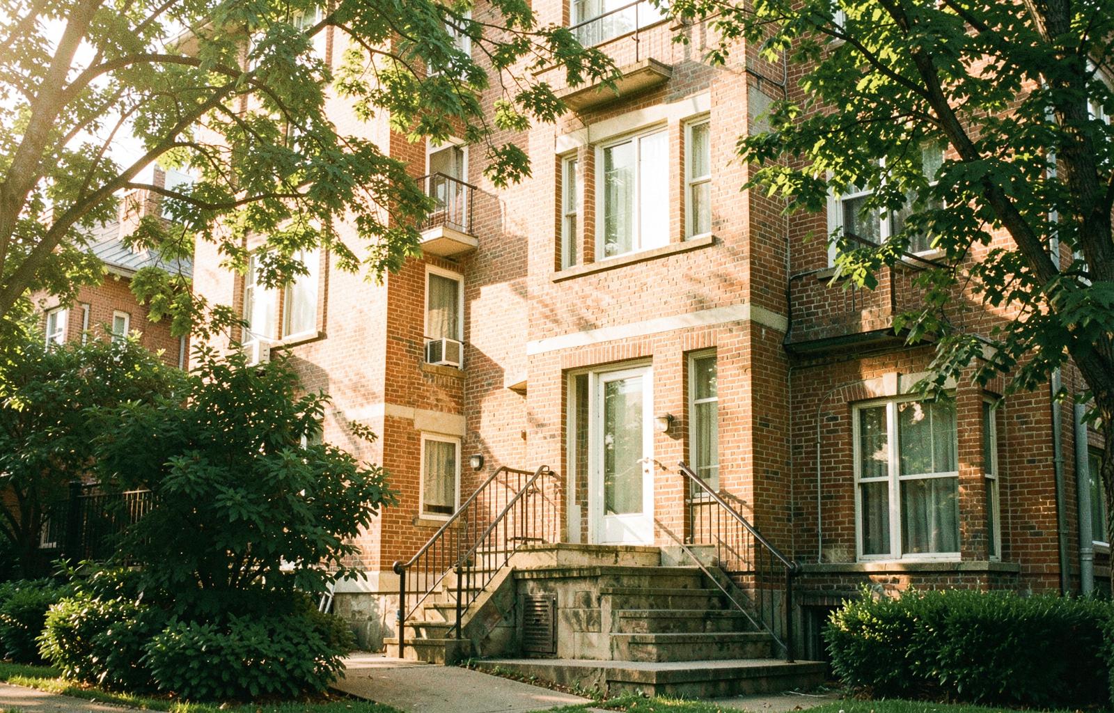 A sunlit residential building whose residents build credit through RateLoft rent reporting